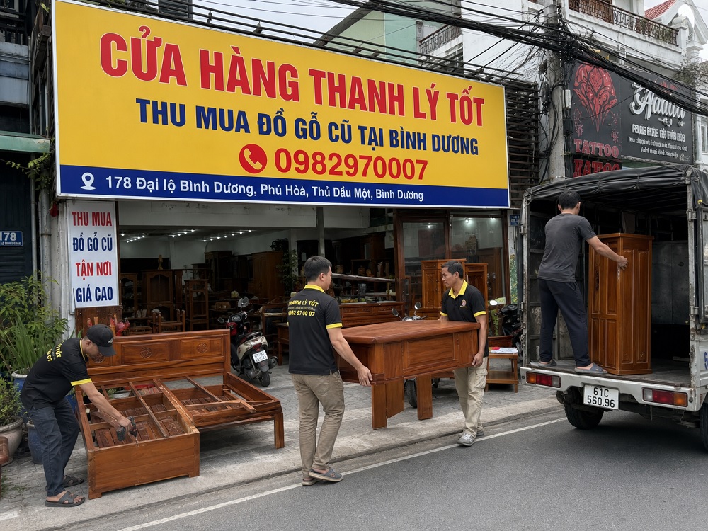 Hình ảnh nhân viên bốc xếp đồ gỗ xuống cửa hàng sau khi thu mua vế